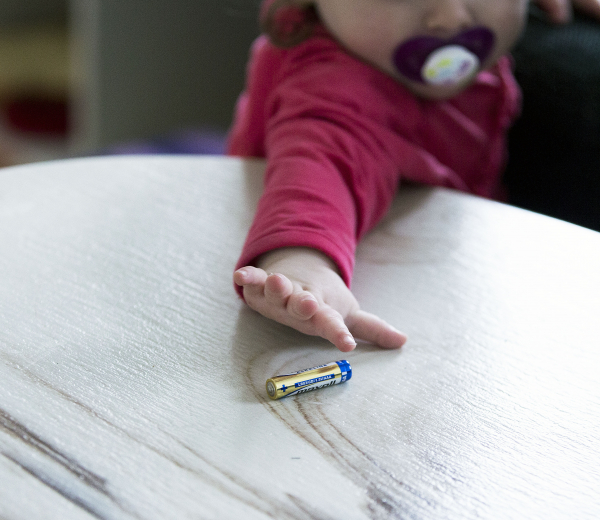 Et barn der rækker ud efter et batteri